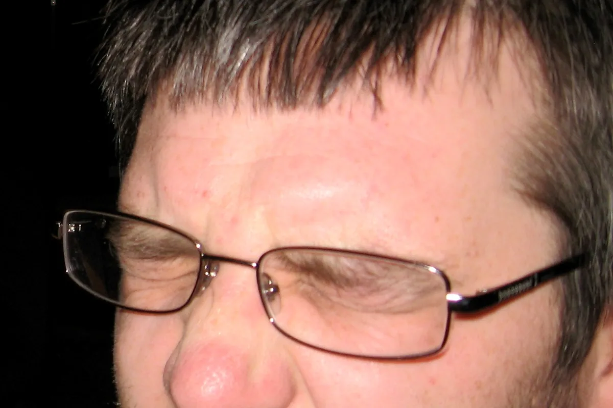 A close-up of a man's face expressing disgust.