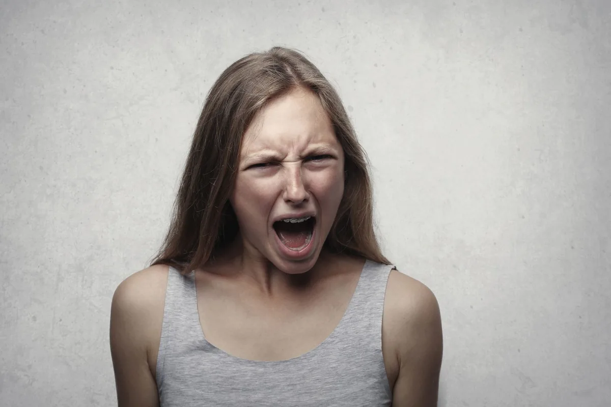 A woman screaming with an intense, angry expression.