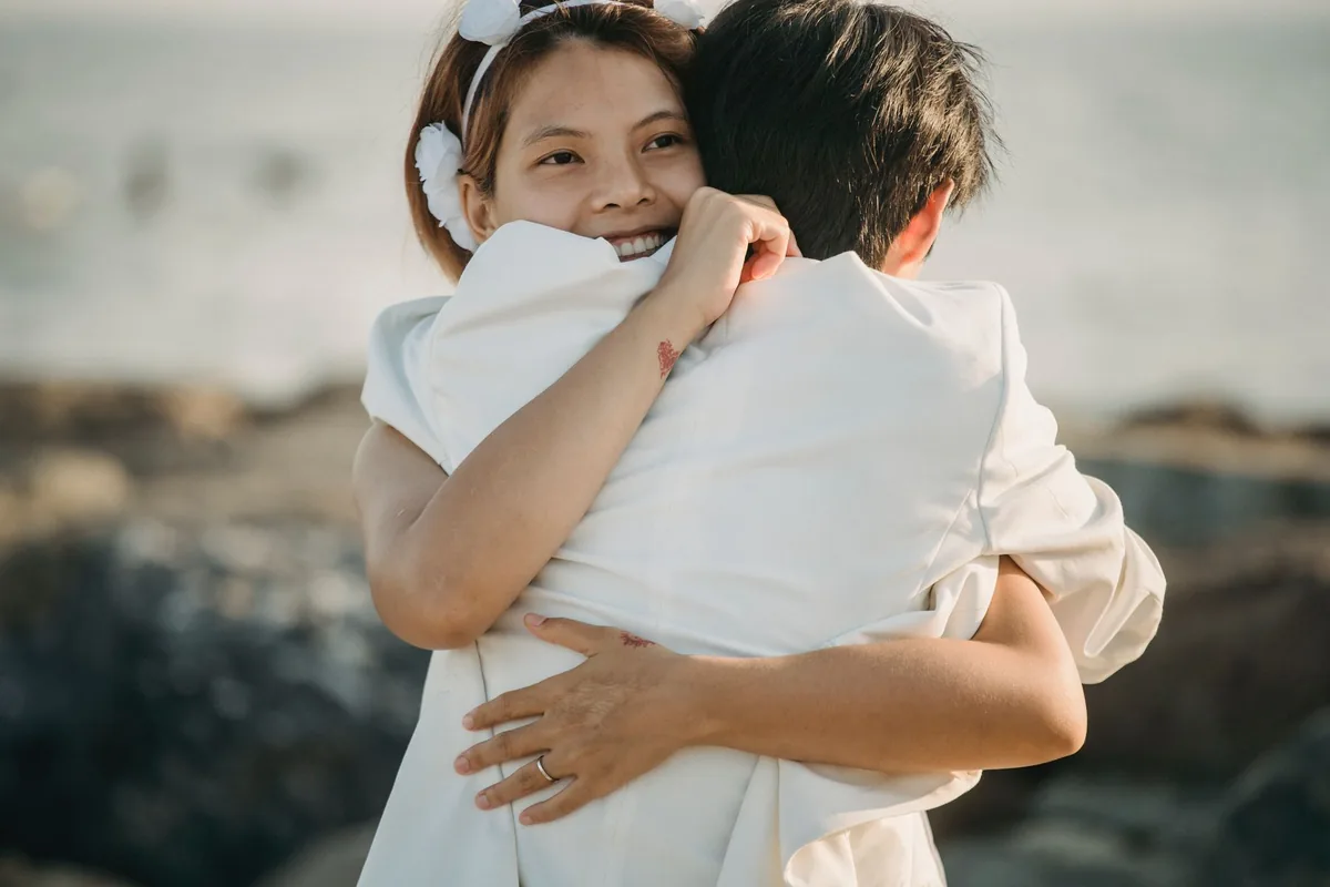 A couple sharing a warm embrace by the seaside.